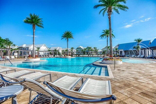 community pool with a residential view, a patio, and fence