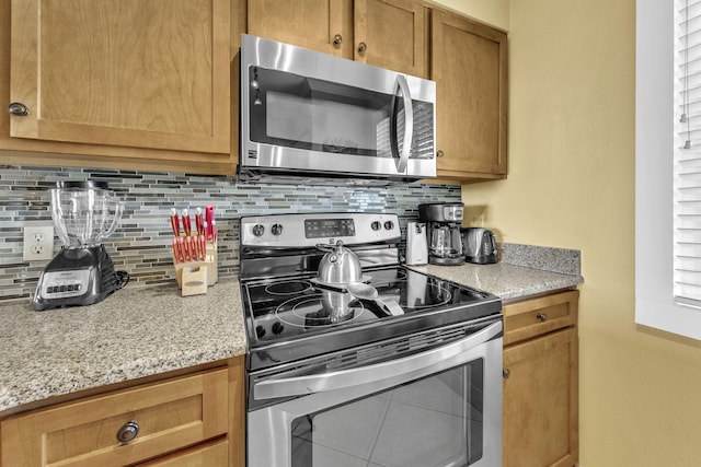 502 Gulf Shore Dr Unit 413, Destin, FL 32541 - kitchen featuring stainless steel appliances, tasteful backsplash, and light stone counters