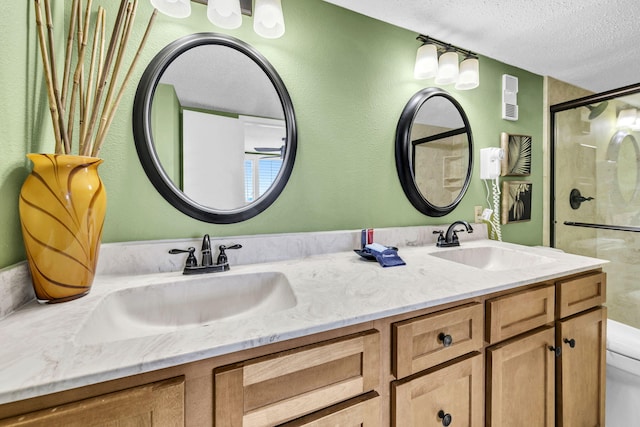 502 Gulf Shore Dr Unit 413, Destin, FL 32541 - bathroom featuring a textured ceiling, a stall shower, toilet, and double vanity