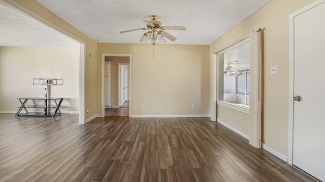 empty room featuring ceiling fan, baseboards, and wood finished floors