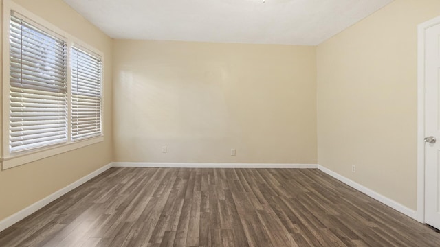 empty room featuring baseboards and wood finished floors
