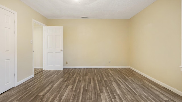 empty room with visible vents, wood finished floors, and baseboards