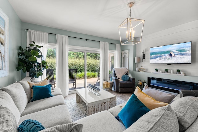 515 Topsl Beach Blvd # 106, Miramar Beach, FL 32550 - living area featuring wood walls, a chandelier, wood finished floors, and a glass covered fireplace