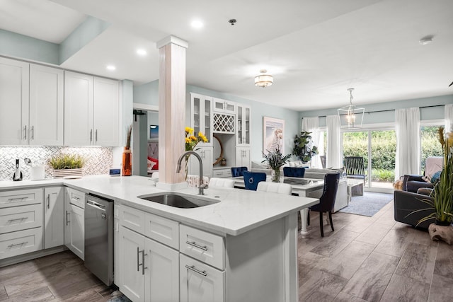 515 Topsl Beach Blvd # 106, Miramar Beach, FL 32550 - kitchen featuring a peninsula, a sink, white cabinets, stainless steel dishwasher, and backsplash