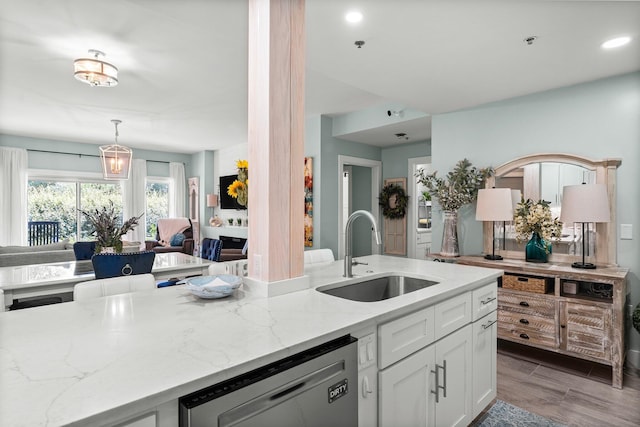 515 Topsl Beach Blvd # 106, Miramar Beach, FL 32550 - kitchen featuring decorative light fixtures, dishwasher, light stone counters, a sink, and white cabinetry