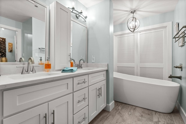 515 Topsl Beach Blvd # 106, Miramar Beach, FL 32550 - bathroom featuring a freestanding bath, an inviting chandelier, double vanity, and a sink