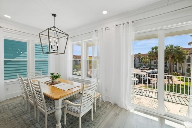 dining space featuring a chandelier, wood finished floors, recessed lighting, and ornamental molding