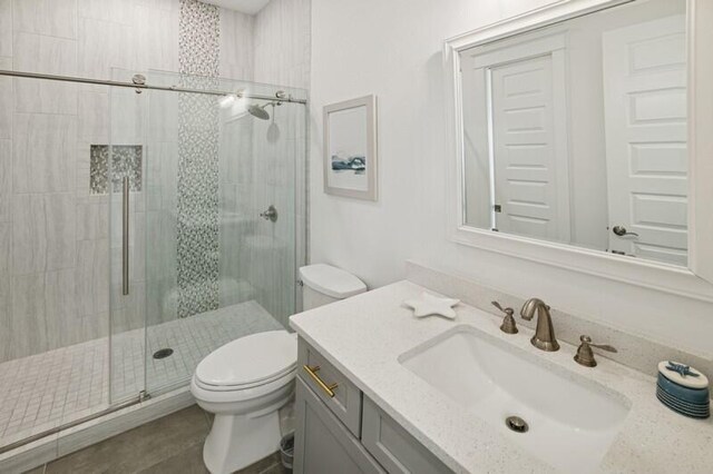 full bathroom featuring toilet, a shower stall, and vanity