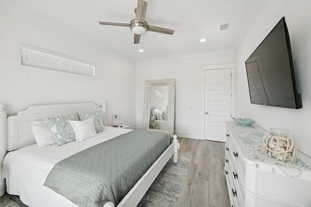 bedroom featuring light wood-style flooring, crown molding, ceiling fan, recessed lighting, and baseboards