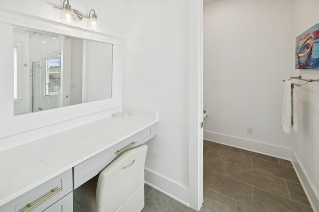 unfurnished office with baseboards and dark tile patterned floors