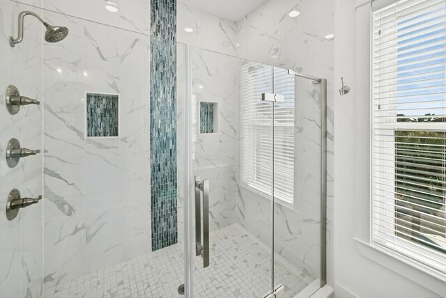 bathroom featuring a marble finish shower and plenty of natural light