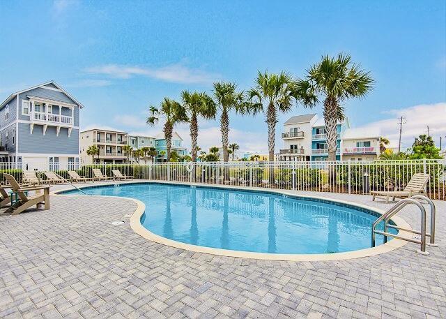 community pool with fence and a patio
