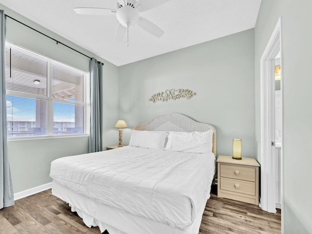 bedroom featuring wood finished floors, baseboards, and ceiling fan