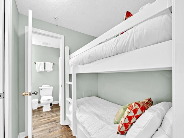 bedroom featuring wood finished floors and a textured ceiling