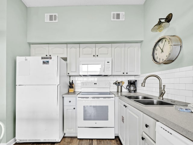 kitchen with white appliances, a sink, white cabinetry, and tasteful backsplash