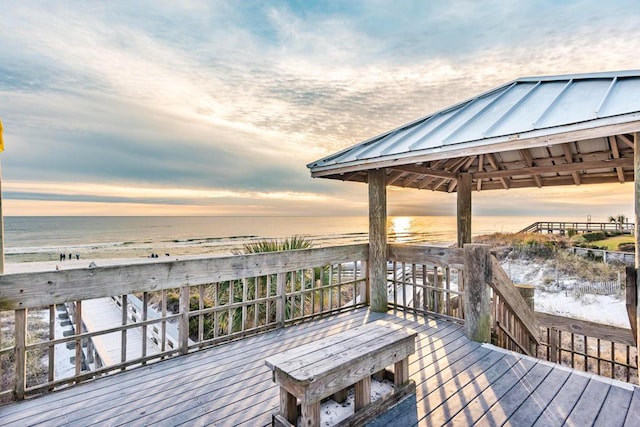 wooden terrace with view of water and beach