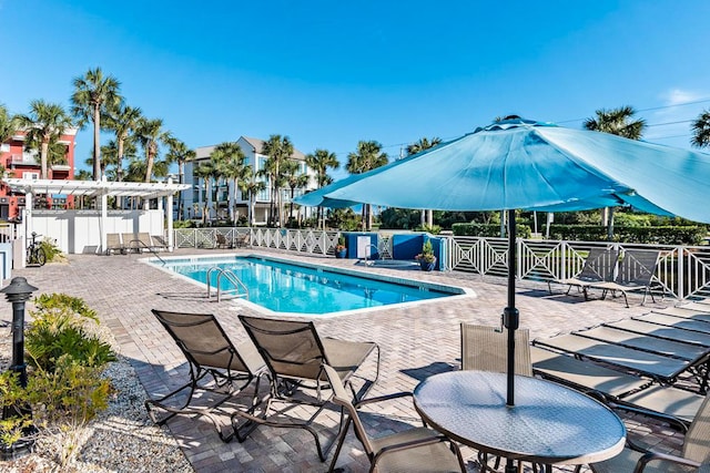 community pool featuring fence, a patio area, and a pergola