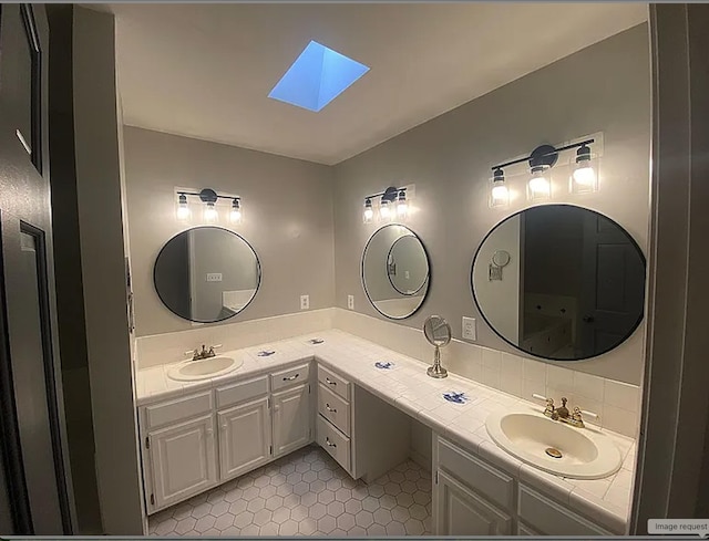 941 Walton Bridge Rd, Ponce De Leon, FL 32455 - bathroom with a skylight, double vanity, and tile patterned floors