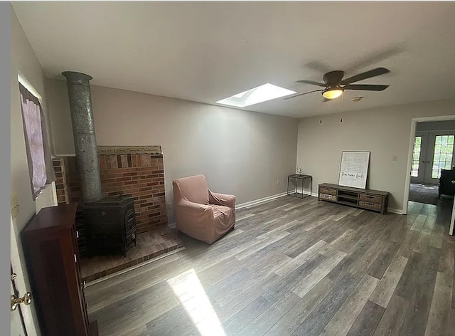 941 Walton Bridge Rd, Ponce De Leon, FL 32455 - sitting room featuring a skylight, wood finished floors, a ceiling fan, a wood stove, and baseboards