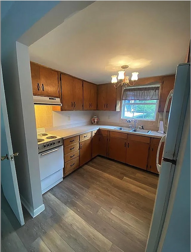 941 Walton Bridge Rd, Ponce De Leon, FL 32455 - kitchen featuring white appliances, a sink, dark wood-style flooring, a chandelier, and under cabinet range hood