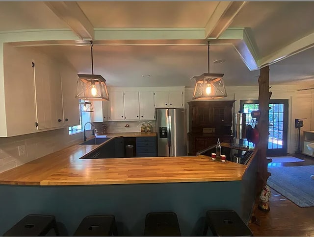 941 Walton Bridge Rd, Ponce De Leon, FL 32455 - kitchen featuring stainless steel refrigerator with ice dispenser, a sink, a peninsula, healthy amount of natural light, and beamed ceiling