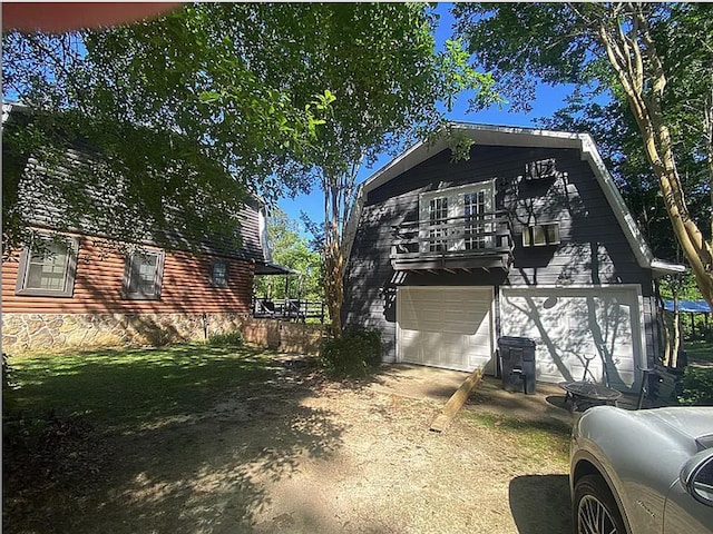 941 Walton Bridge Rd, Ponce De Leon, FL 32455 - view of side of property featuring driveway, a garage, a balcony, and a gambrel roof