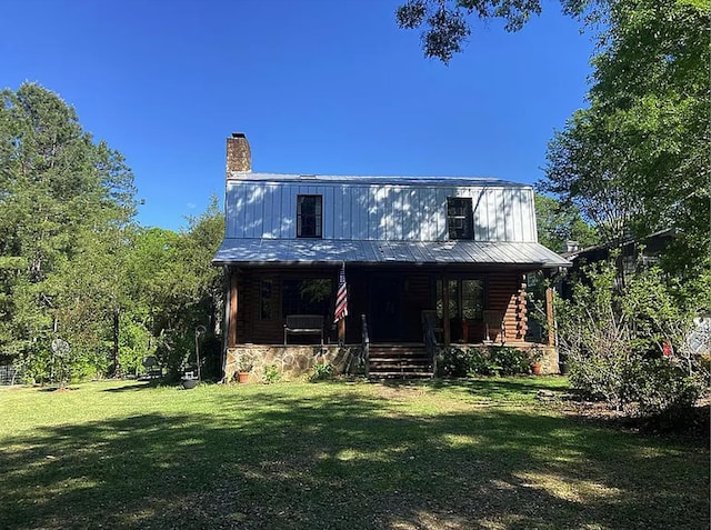 941 Walton Bridge Rd, Ponce De Leon, FL 32455 - view of front facade with a porch, a chimney, a front yard, and metal roof