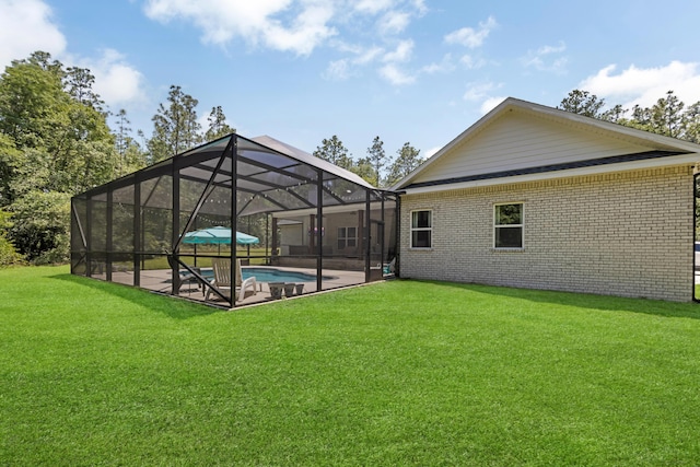5881 Stacy Ln, Crestview, FL 32536 - rear view of property with an outdoor pool, brick siding, a lawn, a patio, and glass enclosure