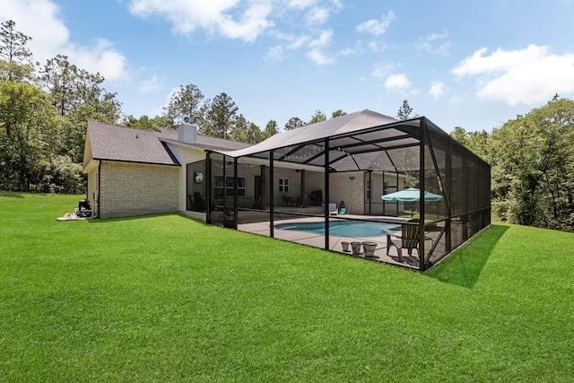 5881 Stacy Ln, Crestview, FL 32536 - rear view of house with a patio, an outdoor pool, a chimney, a yard, and glass enclosure