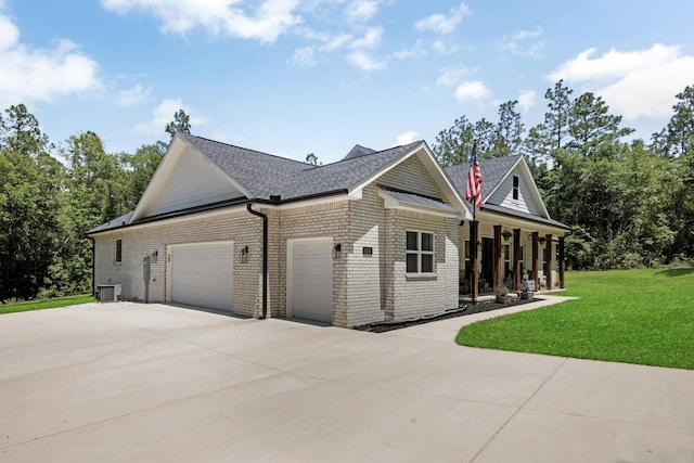 5881 Stacy Ln, Crestview, FL 32536 - view of side of home with driveway, an attached garage, a lawn, brick siding, and a shingled roof
