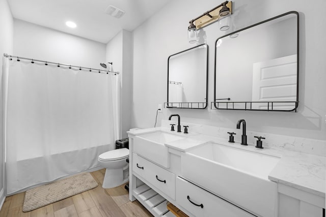 5881 Stacy Ln, Crestview, FL 32536 - full bath with double vanity, shower / tub combo with curtain, toilet, wood finished floors, and recessed lighting