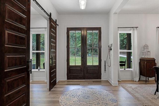 5881 Stacy Ln, Crestview, FL 32536 - foyer entrance with a barn door, plenty of natural light, light wood finished floors, and baseboards