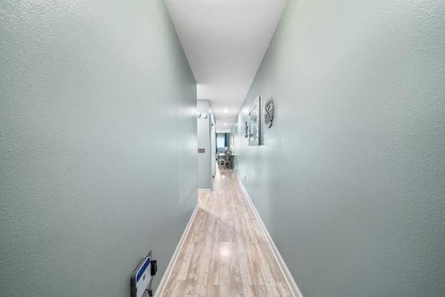 8294 E County Highway 30a Unit 1, Alys Beach, FL 32461 - hall with light wood-type flooring, baseboards, and a textured wall