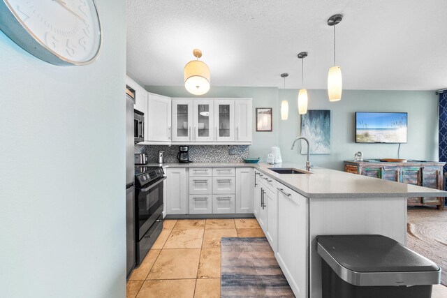 8294 E County Highway 30a Unit 1, Alys Beach, FL 32461 - kitchen with a sink, a peninsula, black electric range oven, decorative backsplash, and white cabinetry