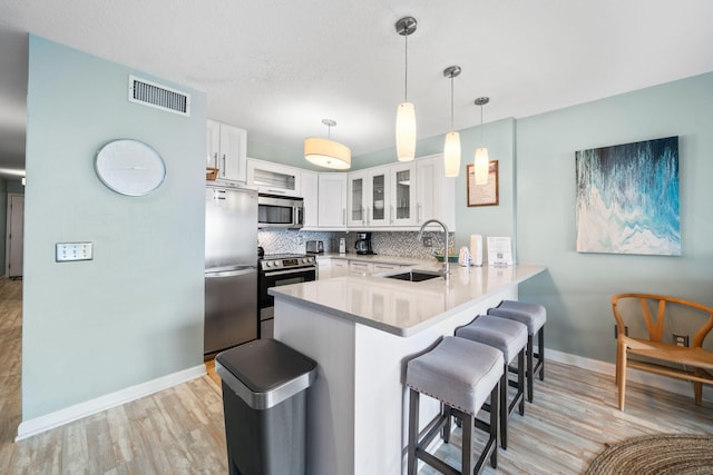 8294 E County Highway 30a Unit 1, Alys Beach, FL 32461 - kitchen featuring stainless steel appliances, a peninsula, a sink, a kitchen breakfast bar, and baseboards