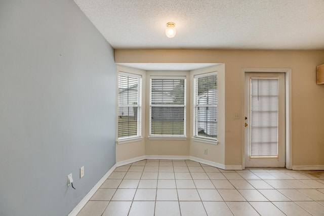 15 Flora Cv, Crestview, FL 32539 - doorway with healthy amount of natural light, light tile patterned flooring, baseboards, and a textured ceiling