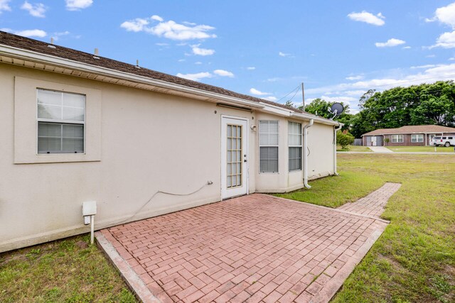 15 Flora Cv, Crestview, FL 32539 - back of house with a patio, a lawn, and stucco siding