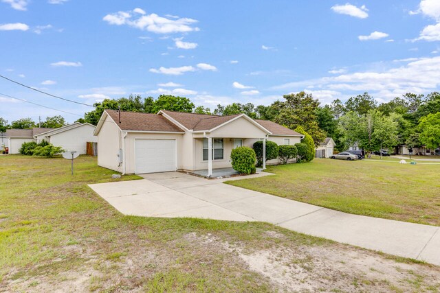 15 Flora Cv, Crestview, FL 32539 - ranch-style house with a garage, a front yard, driveway, and stucco siding