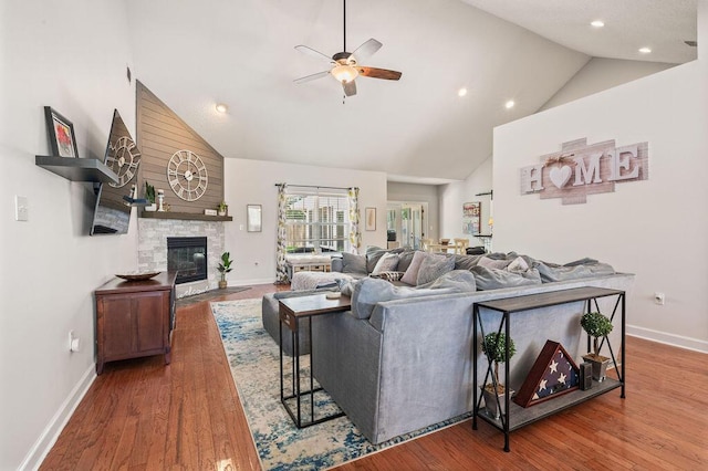 4475 New Market Rd, Niceville, FL 32578 - living room with high vaulted ceiling, ceiling fan, baseboards, a fireplace, and wood finished floors