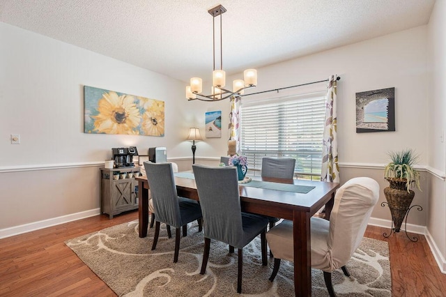 4475 New Market Rd, Niceville, FL 32578 - dining room featuring wood finished floors, a chandelier, baseboards, and a textured ceiling