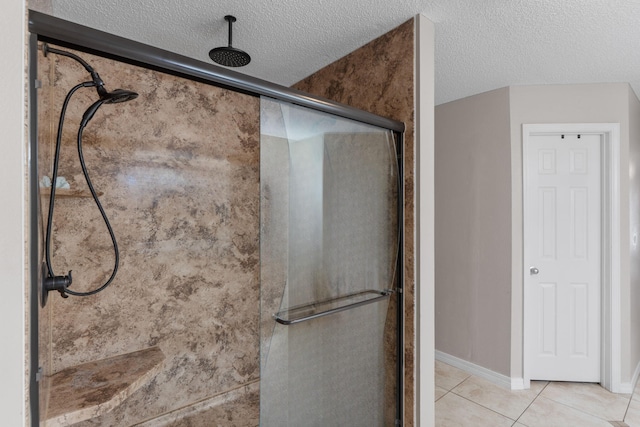 full bathroom featuring a shower stall, tile patterned flooring, and a textured ceiling