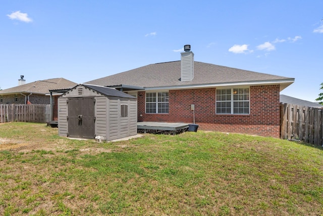 rear view of property featuring a storage shed, brick siding, an outbuilding, a chimney, and a deck
