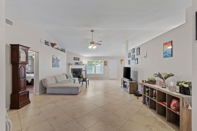 living area with ceiling fan, light tile patterned floors, lofted ceiling, a fireplace, and baseboards