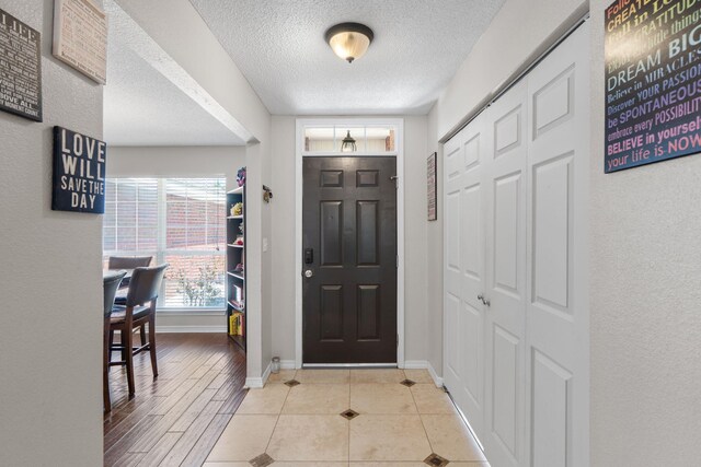 entrance foyer with a textured ceiling and baseboards