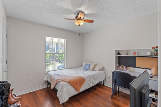 bedroom featuring hardwood / wood-style flooring, a desk, a textured ceiling, baseboards, and ceiling fan