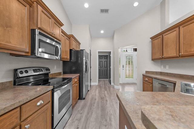 2354 Barberee Dr, Crestview, FL 32536 - kitchen with appliances with stainless steel finishes, light wood finished floors, brown cabinetry, recessed lighting, and baseboards