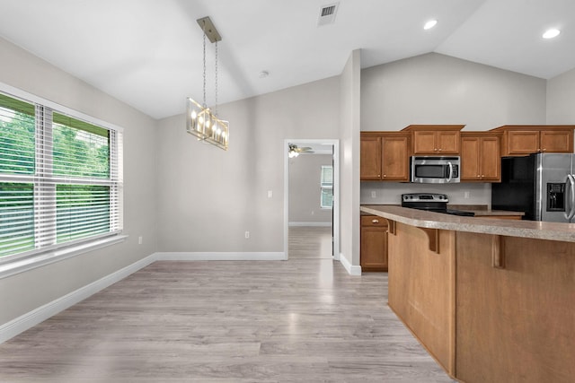 2354 Barberee Dr, Crestview, FL 32536 - kitchen featuring appliances with stainless steel finishes, a breakfast bar area, brown cabinetry, high vaulted ceiling, and light countertops