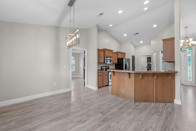 2354 Barberee Dr, Crestview, FL 32536 - kitchen with a chandelier, appliances with stainless steel finishes, a kitchen bar, light wood-type flooring, and high vaulted ceiling