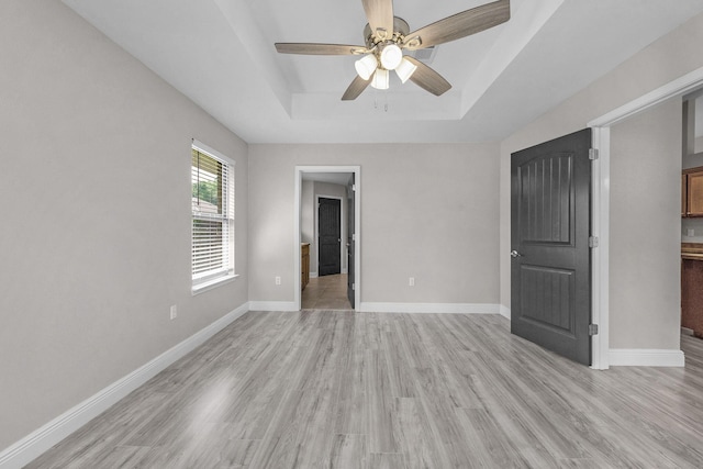 2354 Barberee Dr, Crestview, FL 32536 - unfurnished bedroom with a raised ceiling, light wood finished floors, baseboards, and connected bathroom