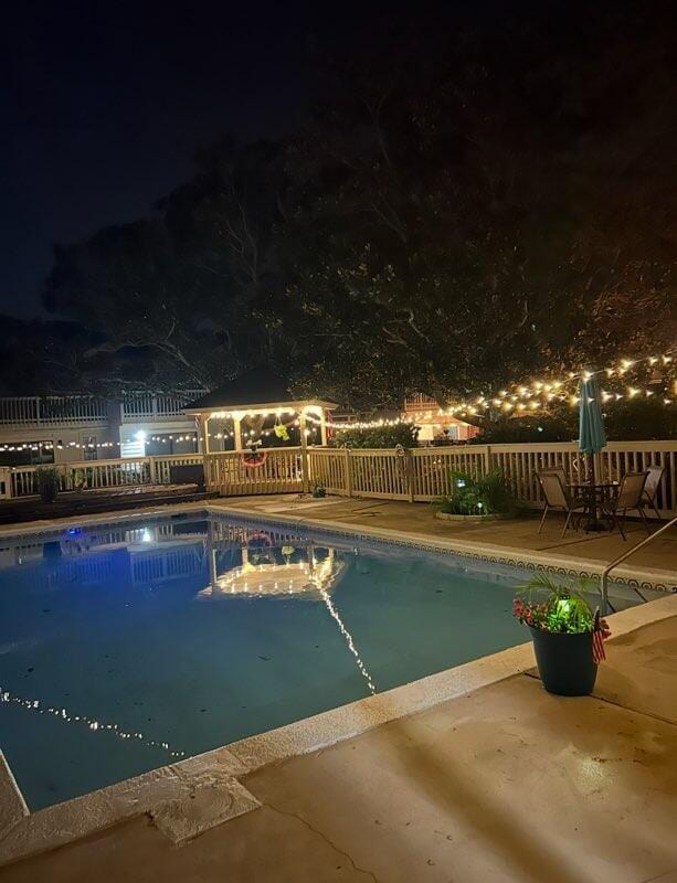 3861 Indian Trl Unit 102, Destin, FL 32541 - pool at night featuring a gazebo and a patio area